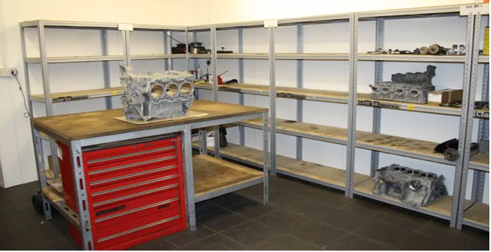 One of the two plastic-lined engine assembly clean rooms, with an engine on a stand and a bench.