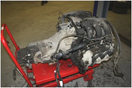 An engine and gearbox removed from the car and sitting on a trolley.