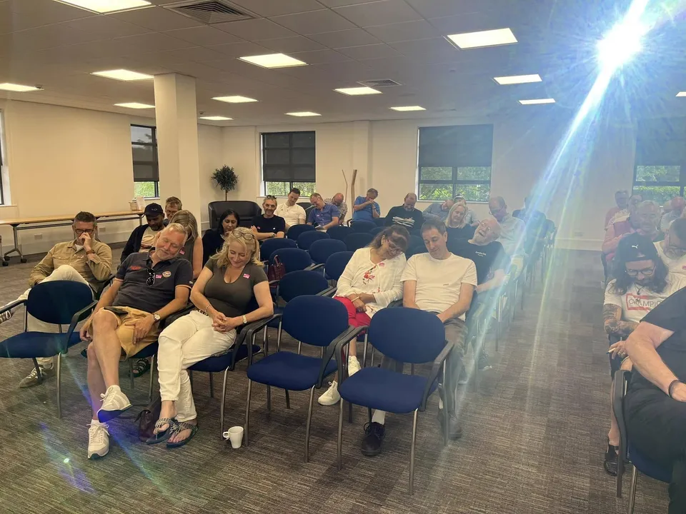 An audience seated in a hall for a Hartech technical talk, the Hartech logo on the screen at the front.