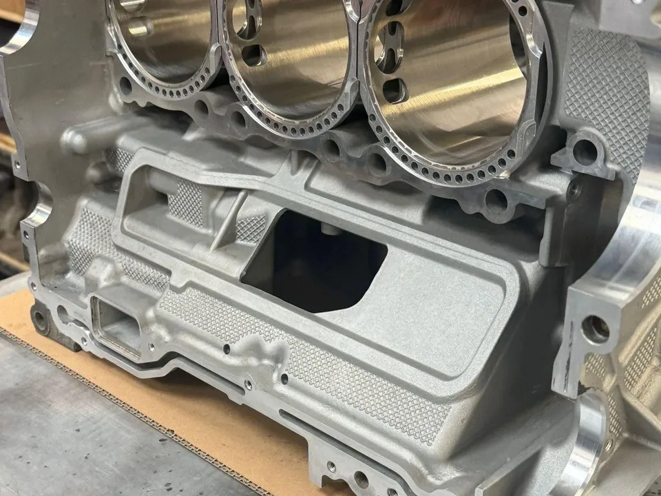 A freshly machined M96 crankcase half on the bench with three new Hartech Nikasil alloy liners fitted, viewed from the deck face.