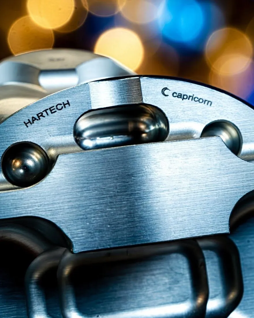 The underside of a Hartech piston, machined and marked with the Hartech and Capricorn names.