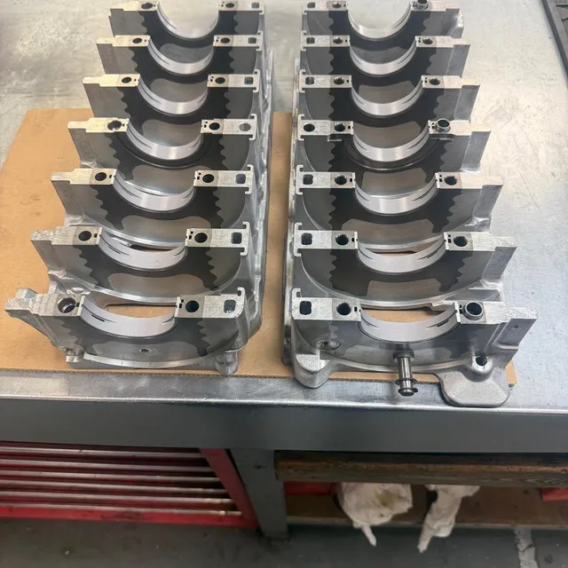 Connecting-rod bearing caps arranged in two neat rows on the bench.