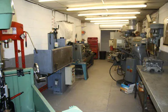 The in-house machine shop with mills and a lathe.