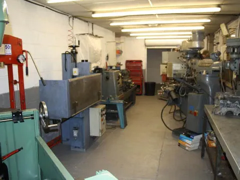 The in-house machine shop with mills and a lathe.